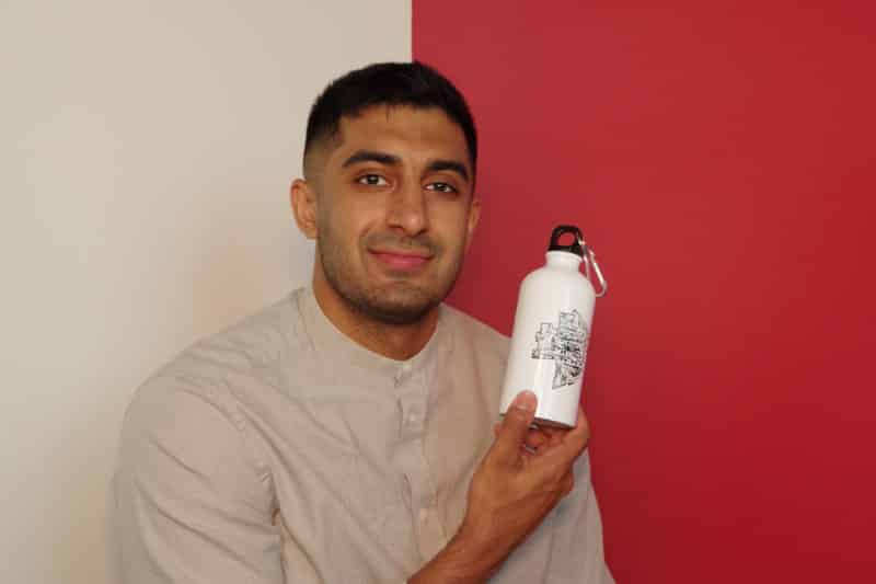 Main Street Project marketing coordinator, Raj Sidhu holding a water bottle donated to their shelter program.